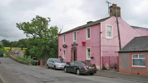 Richard Dorrell The Brig Inn some years ago with cars parked outside and a pink frontage and signs for different types of beer sticking out from the front wall