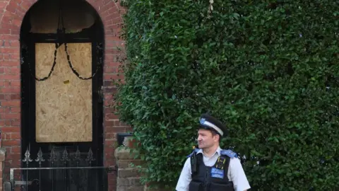 Image shows a police officer standing outside the private home of Prime Minister Keir Starmer after it was damaged by fire in a suspected arson attack in north London, Britain, on 13 May 13, 2025
