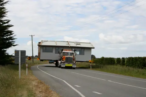 Hilary Steele A lorry moves a mobile home along a road