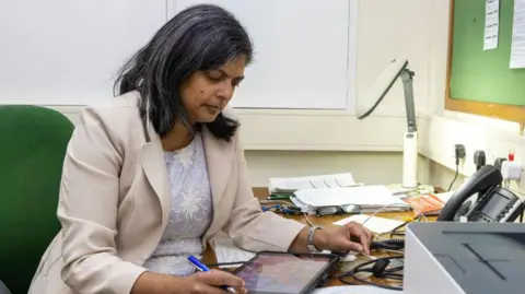 Getty Images Rupa Huq at work on an iPad in her office 