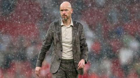 Manchester United boss Erik ten Hag walks in the rain at Old Trafford 