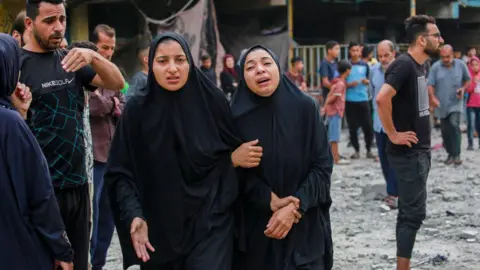AFP Palestinians react after an Israeli strike on a UN school in Nuseirat refugee camp, in the central Gaza Strip (6 June 2024)
