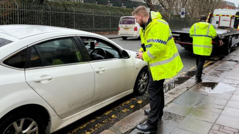 A police officer talking to a parked car driver