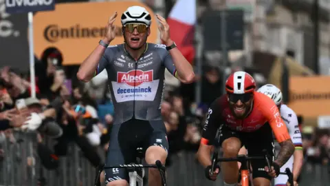 Alpecin-Deceuninck rider Mathieu van der Poel puts his hands to his head as he wins the 2025 Milan-San Remo ahead of Filippo Ganna and Tadej Pogacar