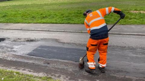 Worker fixing a pothole 