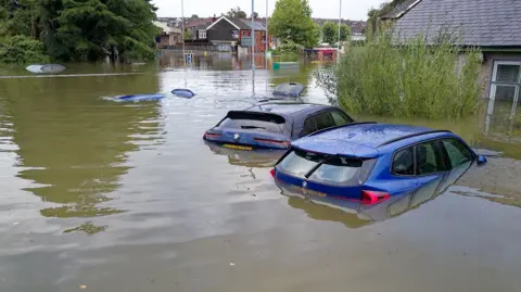 A number of cars submerged in water in a car park