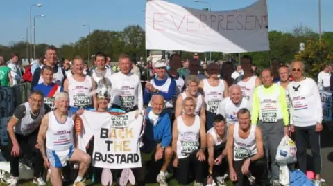 www.everpresent.org.uk A group of runners pose with a banner saying "Ever Present".