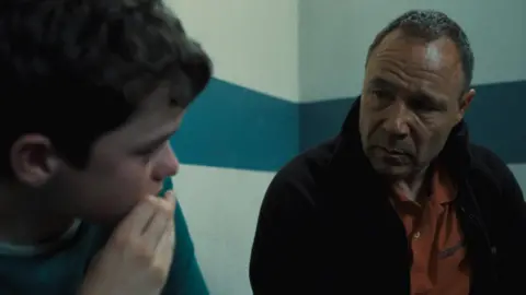 Netflix Owen Cooper and Stephen Graham in a police waiting room looking pensive