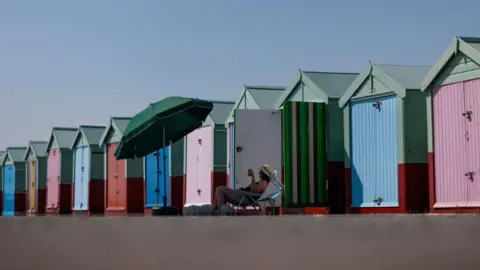 Getty Images A line of colourful beach huts. 