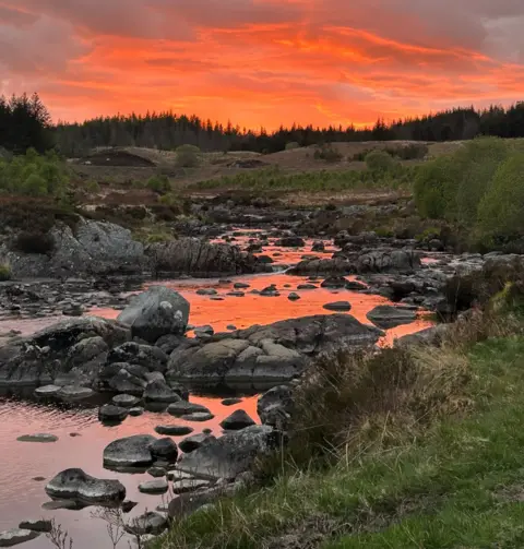 Gavin Rorison A stony stream with an orange reflection from the sun 