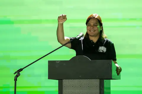Getty Images Sara Duterte pumping her fist in the air at a podium