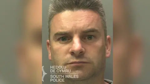 South Wales Police Christopher Cooper mugshot. He has grey short hair. 