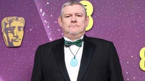Getty Images John Davidson attends the 2026 EE BAFTA Film Awards at The Royal Festival Hall on February 22, 2026 in London, England