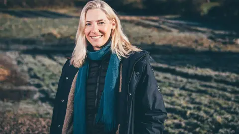 Food Sense Wales Founder of Food Sense Wales charity Katy Palmer standing in a field. 