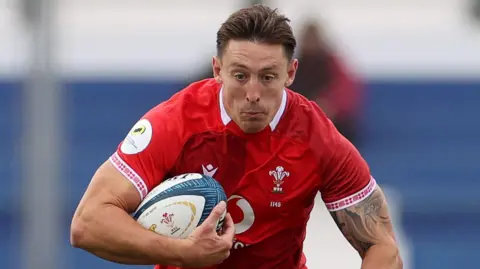 Josh Adams carries the ball under his right arm for Wales in Argentina