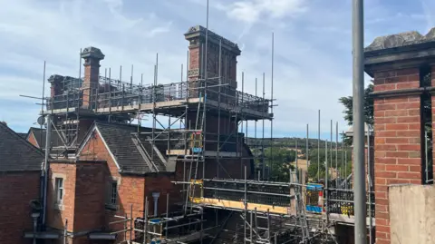 Scaffolding on tall brick chimneys