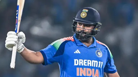 India captain Rohit Sharma raises his bat after reaching a century