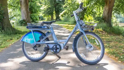 Beryl A bike, resting against a kickstand on a path through what looks like a park. Branding on the bike reads: "beryl".