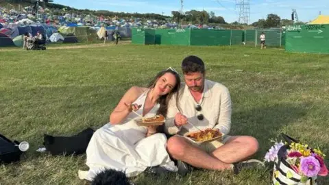 Charlie Shires Charlie and Charles in their white wedding clothes enjoying food from one of Glastonbury's stalls