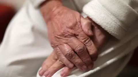 PA Media Photo of an elderly woman's hands