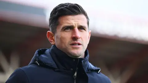 John Mousinho, manager of Portsmouth, looks on prior to the Championship match between Bristol City and Portsmouth at Ashton Gate