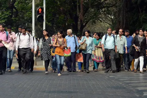 AFP via Getty Images Indian residents walk at a pedestrian crossing in Mumbai 