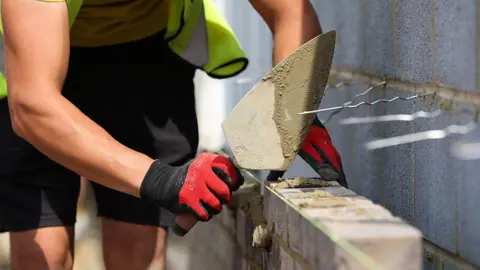 Getty Images A generic picture of a bricklayer laying bricks.