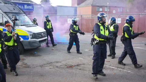 police dealing with flares during unrest in Epping