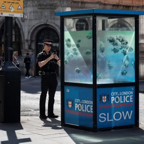 Banksy Police officer taking a photo of the sentry box