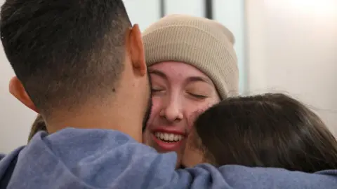 Reuters A zoomed-in crop of Naama Levy smiling as she's hugged by family members during their reunion in Israel on 30 January