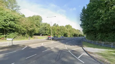 Google A generic photo of a road going from the bottom left on the photo, with trees pictured to the left and right of the street. The image includes a junction with another road at the bottom and a further junction with a different street in the middle.