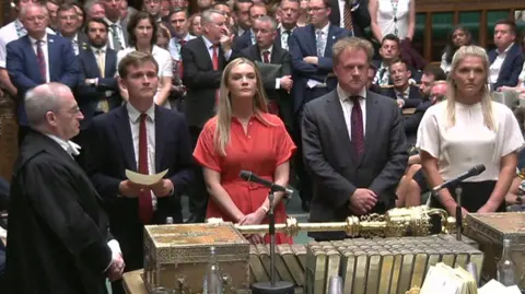 Four MPs acting as tellers announce the vote in the chamber of the House of Commons. They are surrounded by MPs, waiting forthe result.