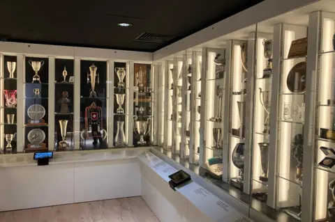 The trophies are displayed in glass cabinets.