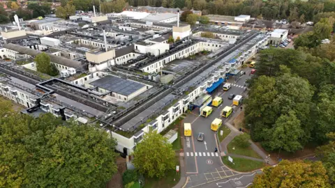 Shaun Whitmore/BBC Aerial view of the Queen Elizabeth Hospital in King's Lynn. It is a sprawling collection of grey and white buildings, surrounded by trees and roads. 
