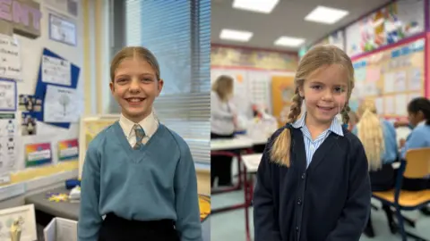 Pictures of Georgia and Hattie are side-by-side and both young girls smile at the camera. Georgia's photo is on the left and she's wearing a light blue sweater top with a v-neck cut and a white shirt underneath and a light blue and grey tie on. Her long blonde hair is tied into a ponytail. Hattie is wearing a dark blue sweater with a blue and white stripped shirt underneath. Her blond hair is tied into two pigtails. 