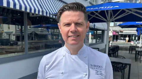 Chef Sy Crockford standing in front of Marina Fish & Chips in Saundersfoot