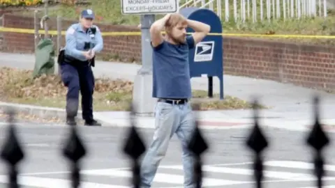 Edgar Maddison Welch being arrested by a Washington DC police officer. 