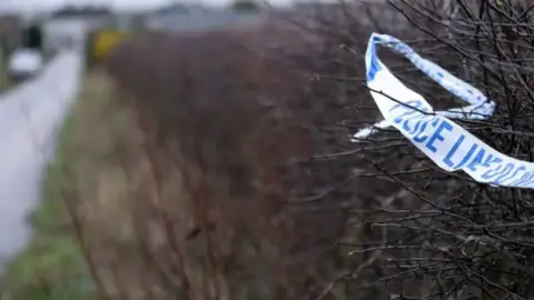 Pacemaker A blue and white police cordon stuck in a leafless bush. 