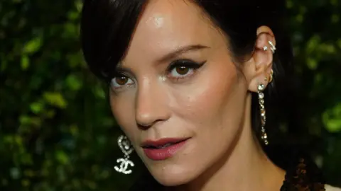 PA Tampilan jarak dekat dari Lily Allen dengan anting-anting menjuntai