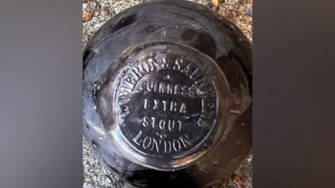 Stefan Panis A black bottle. Written on the top of the cap is 'GUINNESS EXTRA STOUT LONDON'.