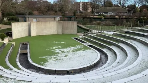 George Carden/BBC An open air theatre with snow settled on the steps.
