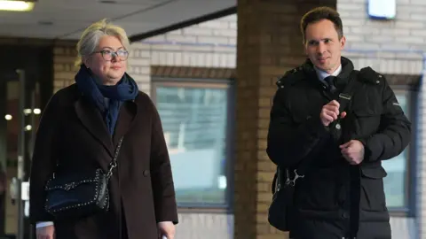 PA Media Image shows Ekaterina Ovsiannikova (left) a blonde woman with glasses and Alexei Owsjanikow (right) a man with brown hair and in a black coat, leaving Southwark Crown Court