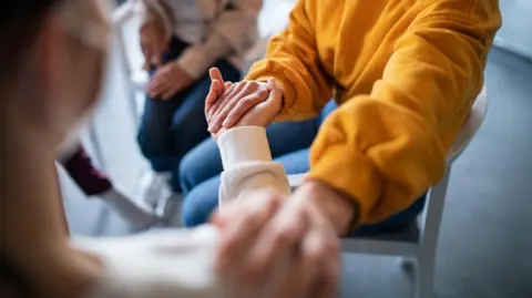 Getty Images Unrecognizable depressed woman in group therapy, counselling 