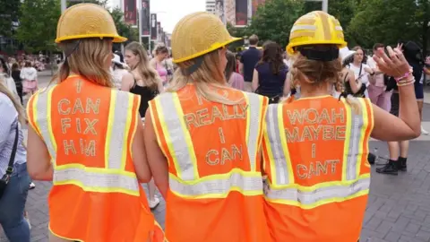 PA Media: Rear view of three women in high visibility vests