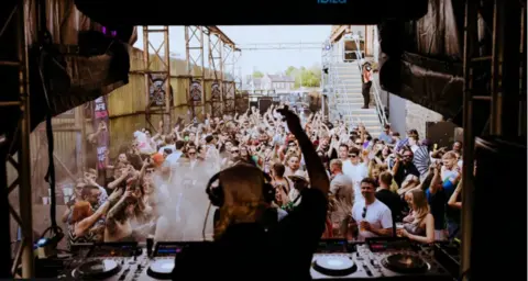 View from behind a DJ whilst they play in the garden of Motion