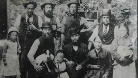 No A black and white image showing 10 residents in working victorian dress