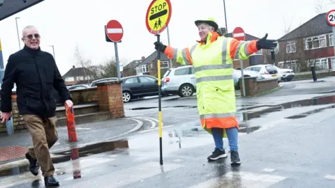 Middlesbrough Council Elaine Dunn helps a man to cross the road