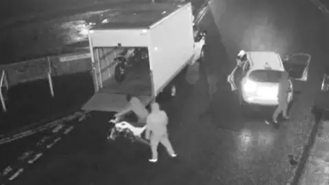 CCTV footage shows a ram-raid at a motorcycle store on Coney Lane in Keighley. Men wearing hooded tops are seen loading motorcycles into the back of a lorry.