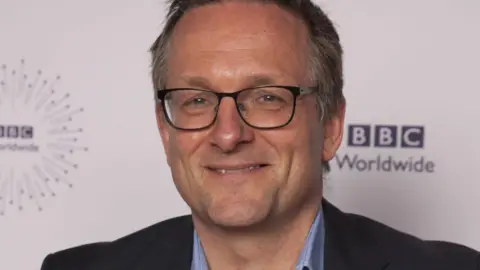 Michael Mosley smiling while wearing glasses