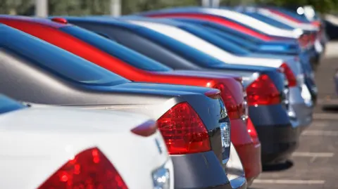 A row of cars sit in a car park in a car park.